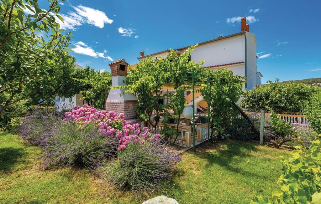 una casa con giardino fiorito in cortile di Hause Lupic a Rab