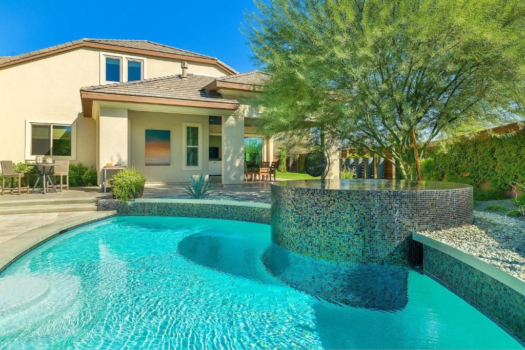 a swimming pool in front of a house at Villa Perfection in Indio