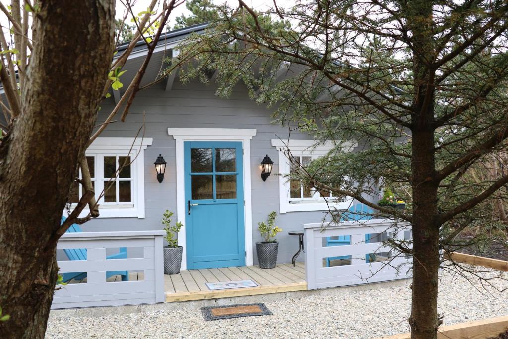 uma pequena casa com uma porta azul em Inisean Lodge log cabin -part of Inisean B&B em Dungloe