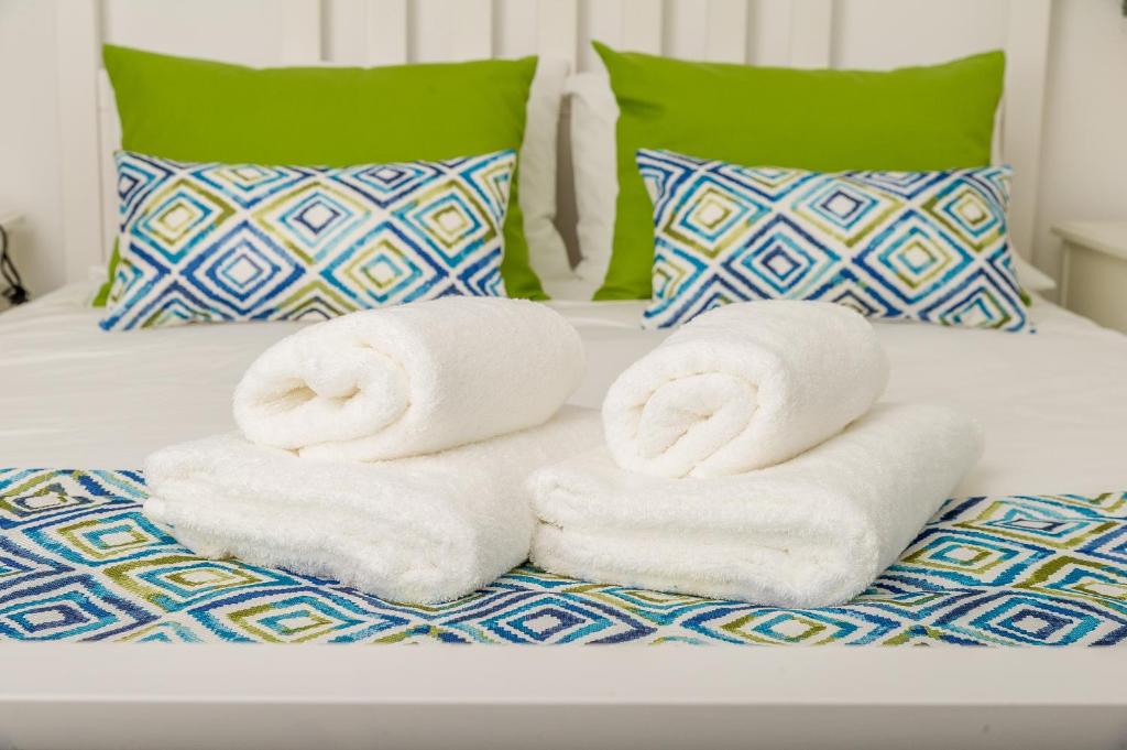 uma pilha de toalhas sentadas em cima de uma cama em Vieira Apartments II em Setúbal