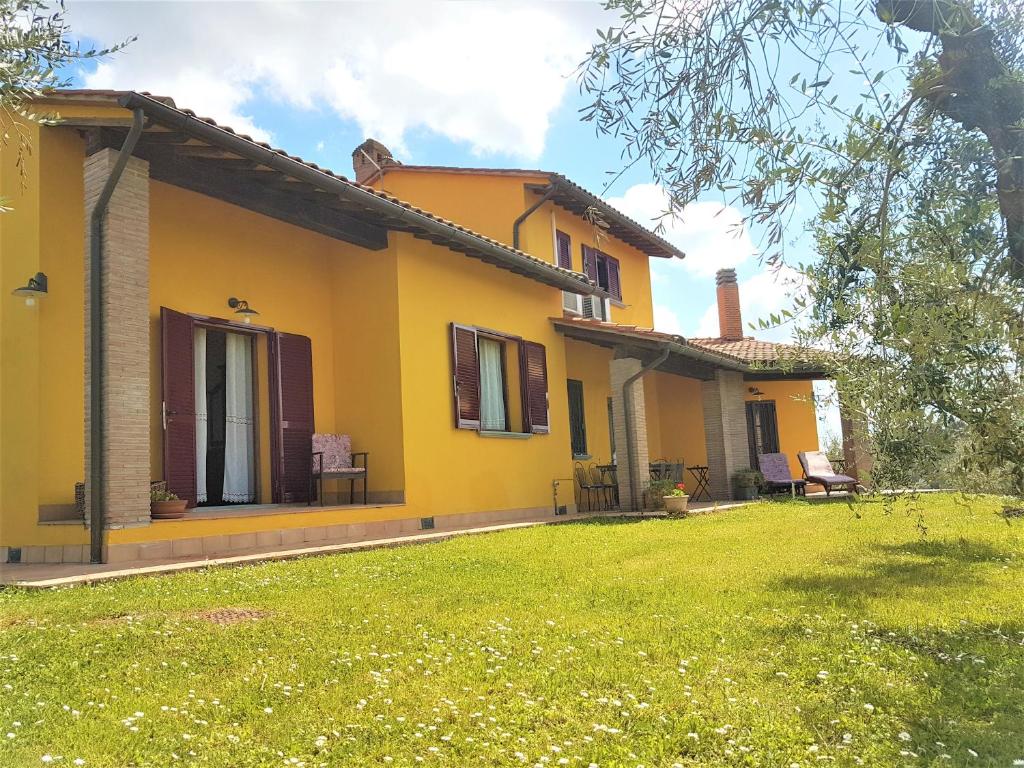 ein gelbes Haus mit Rasen davor in der Unterkunft Villa in campagna Costa al Bagno in Montopoli in Val dʼArno