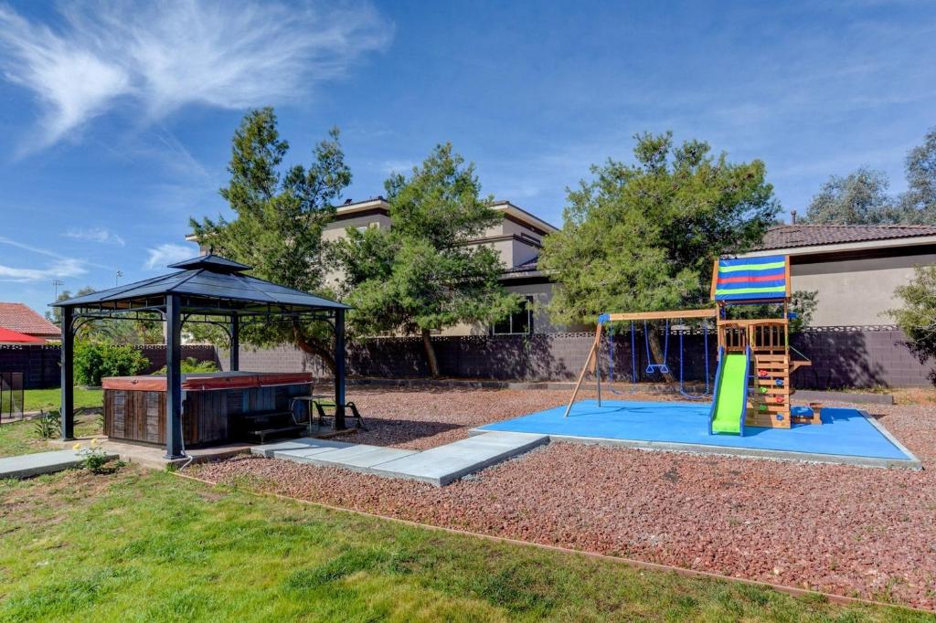 un parque infantil en un patio con una tienda de campaña en Villa Umber, en Las Vegas