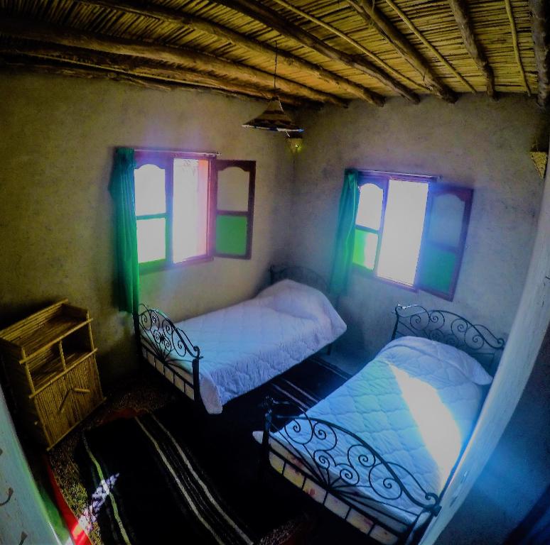 2 literas en una habitación con ventanas en iskki-asnfou, en Tafraoute