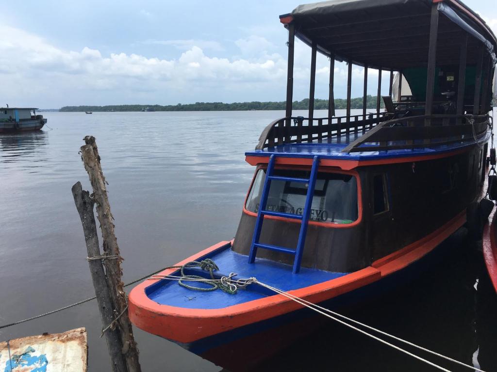 a boat tied up to a dock in the water at Orangutan Houseboat Park Tanjung Puting in Pangkalan Bun