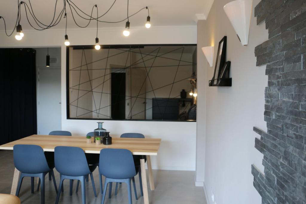een eetkamer met een houten tafel en blauwe stoelen bij Lagos Beach 59A in Lagos