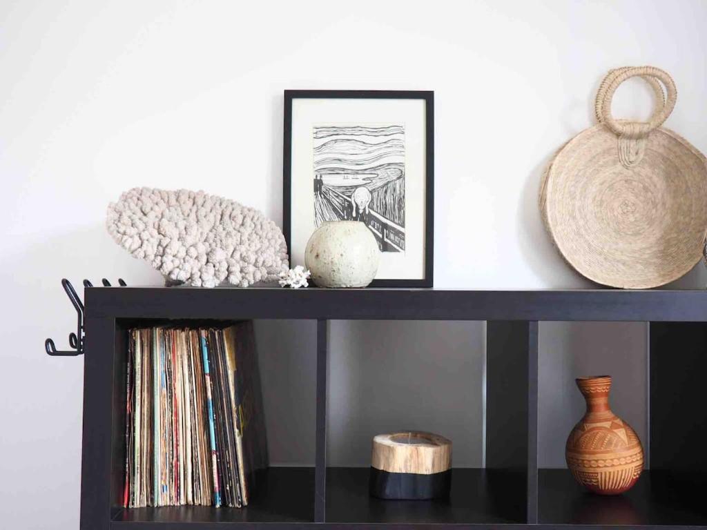 uma prateleira preta com vasos e arte em Maison à deux pas de l'océan em Biscarrosse-Plage