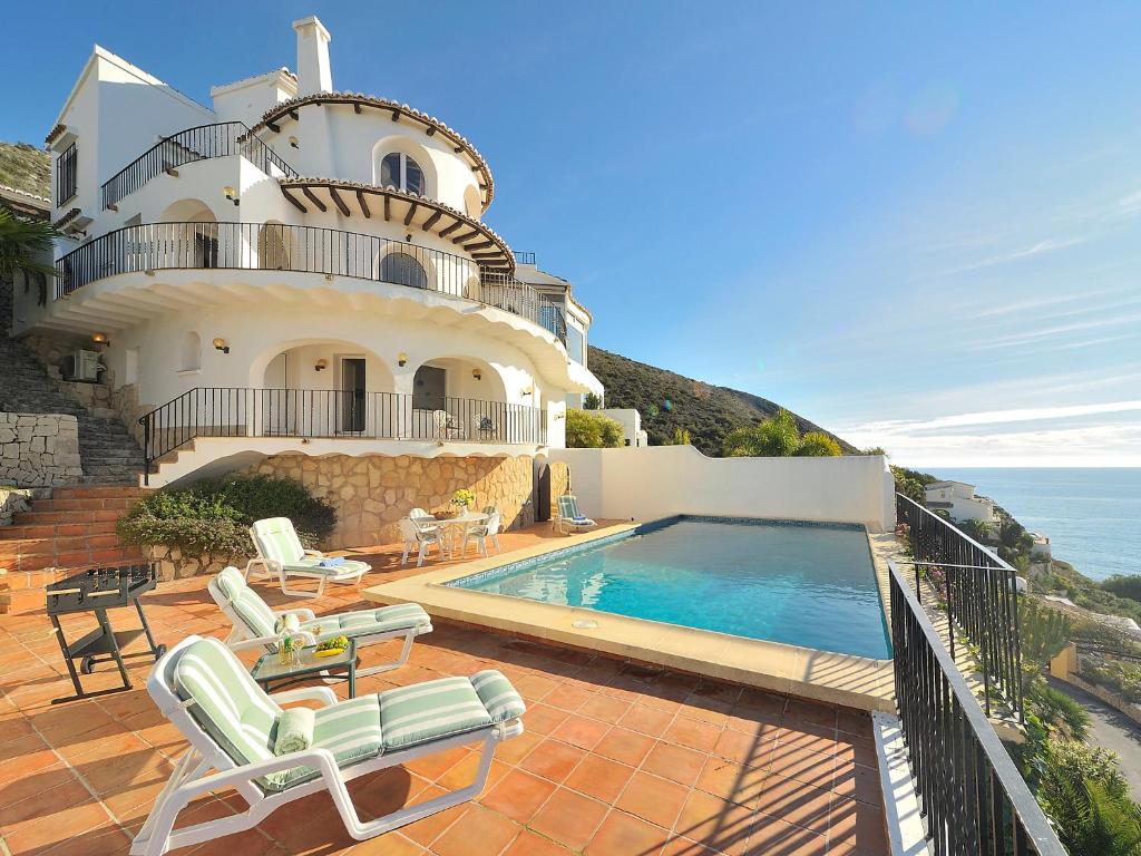 a house with a swimming pool next to the ocean at Villa Vista Panorama by Interhome in Rada de Moraira