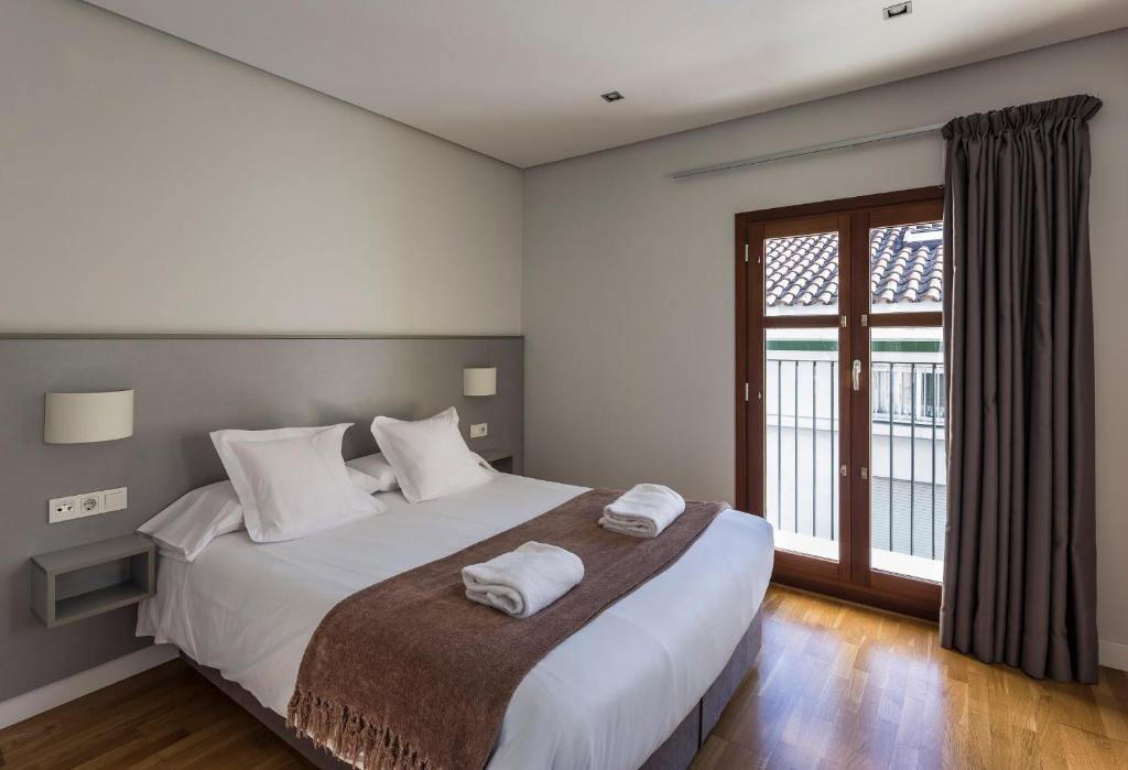 sypialnia z dużym łóżkiem z dwoma ręcznikami w obiekcie Mon Suites Catedral w Walencji