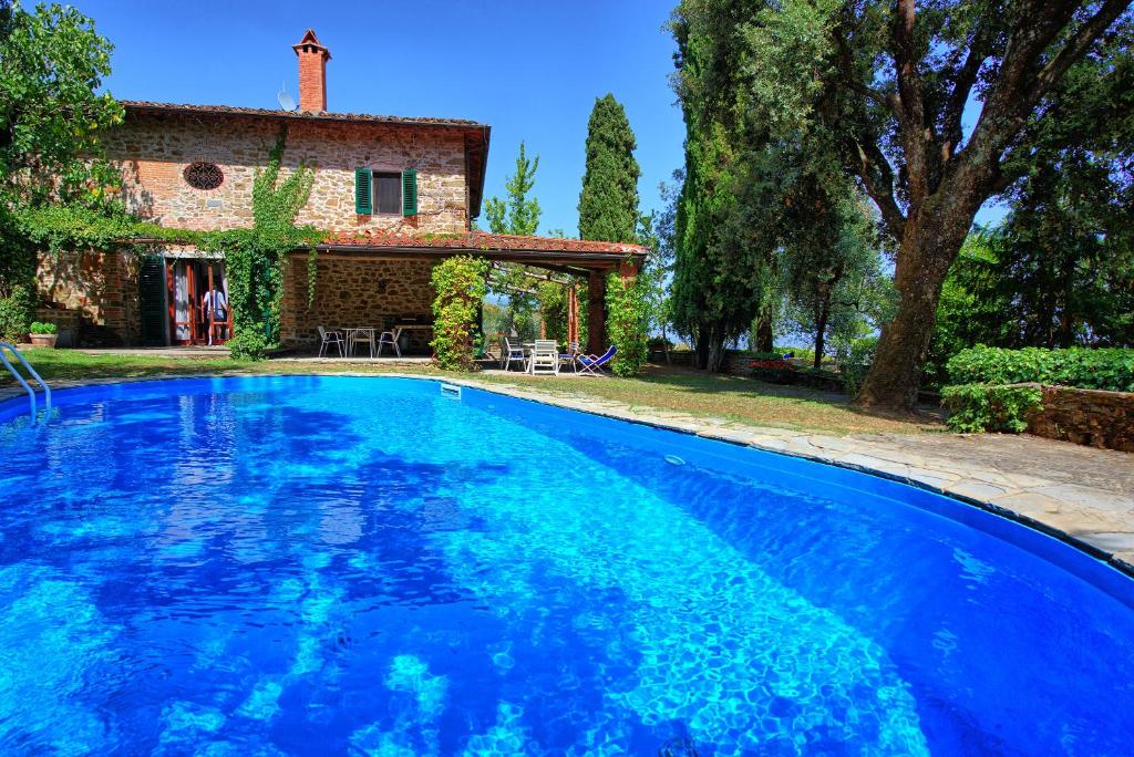 een groot blauw zwembad voor een huis bij Villa Ulivacci by PosarelliVillas in Cavriglia