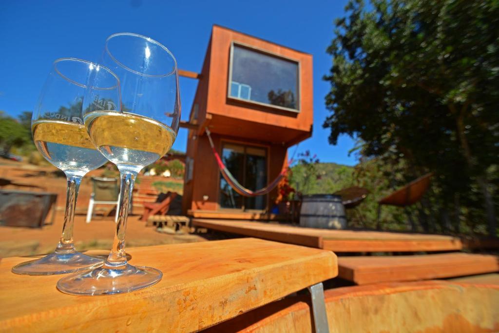 zwei Gläser Wein auf einem Holztisch in der Unterkunft Tinyhouse in the WineValley in Casablanca