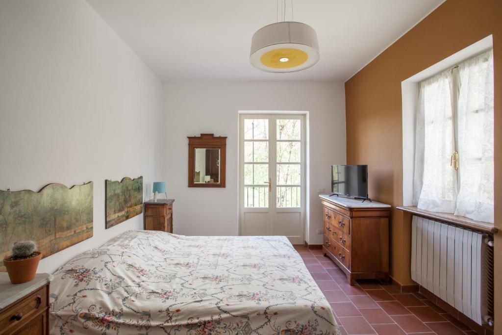 sypialnia z łóżkiem, komodą i oknem w obiekcie AMERICA NEI BOSCHI B&B w mieście Bra