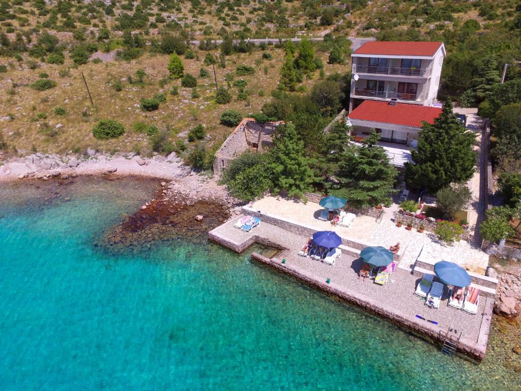 an aerial view of a house with a pool of water at Apartmani Ribarica**** in Karlobag