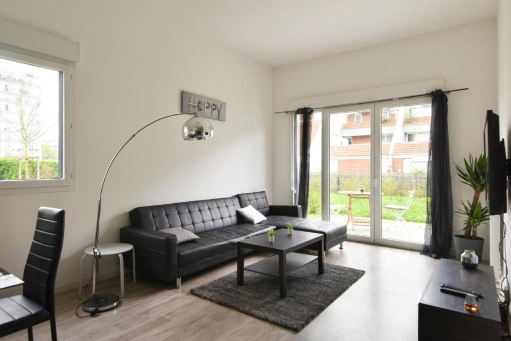 uma sala de estar com um sofá e uma mesa em Spacious 3-rooms with garden close to Lille em Lille