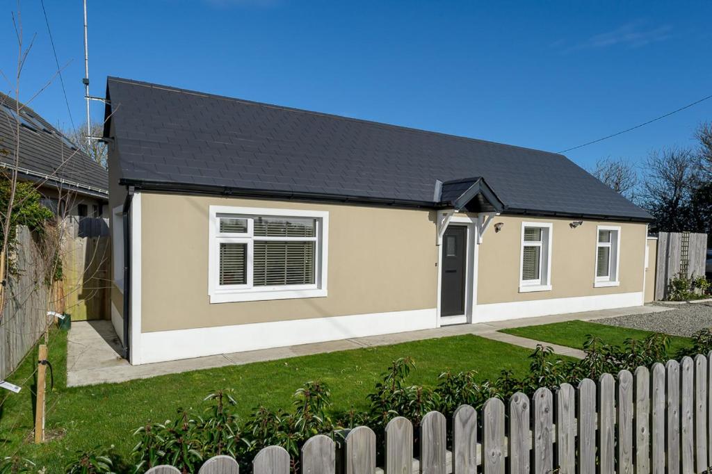 a house with a fence in front of it at Garra Cottage in Drogheda
