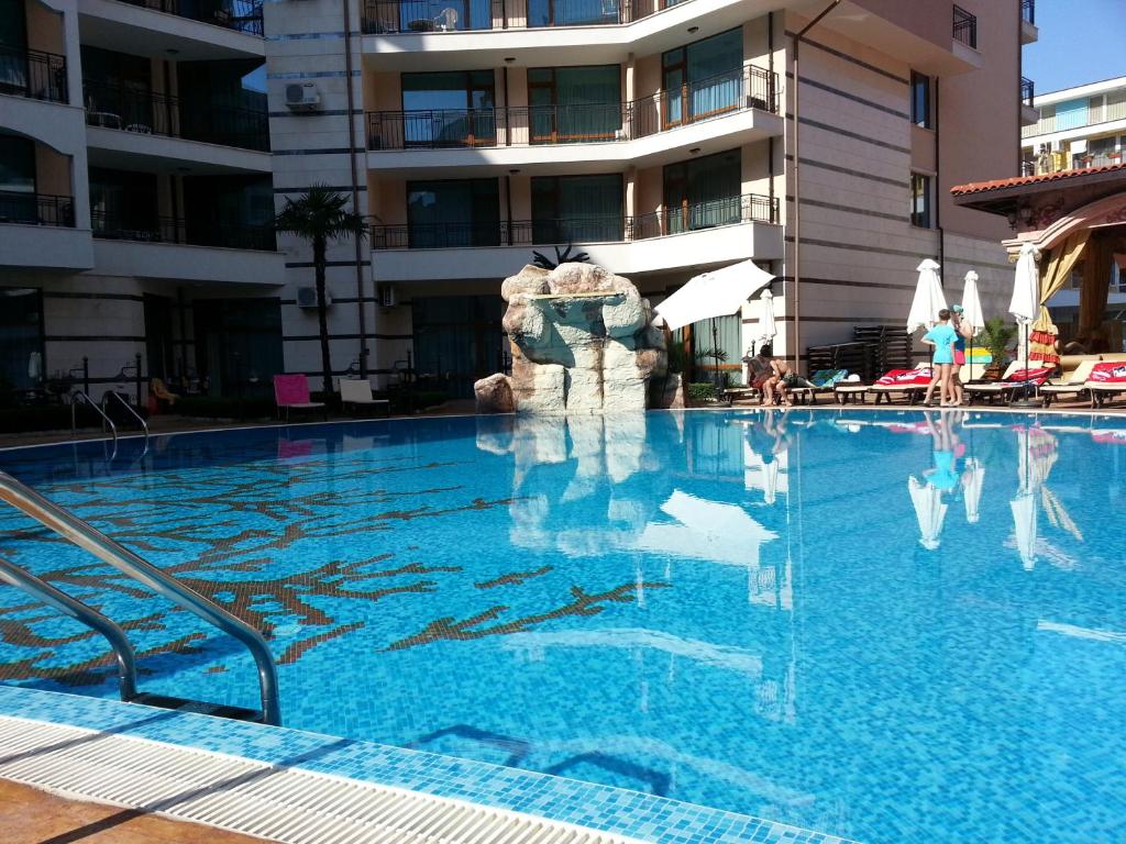 a swimming pool in front of a building at Menada Apartments in Karolina in Sunny Beach