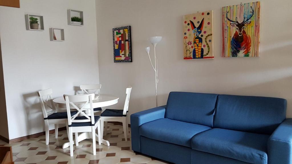 a living room with a blue couch and a table at La Casa fra gli ulivi in Lerici