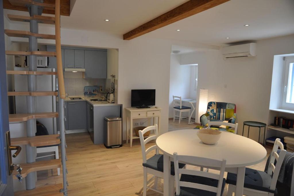 ein Wohnzimmer mit einem Tisch und Stühlen sowie eine Küche in der Unterkunft Apartment Gordana in Cres