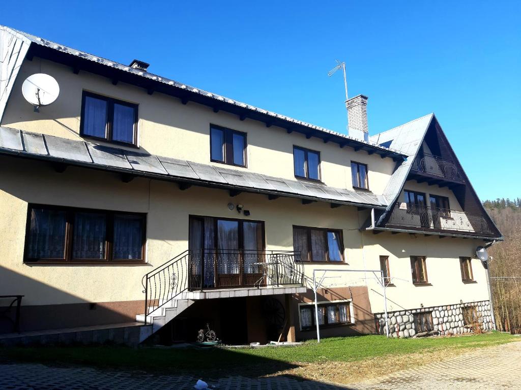 a large white building with windows and a balcony at Pokoje u Heleny in Leśnica