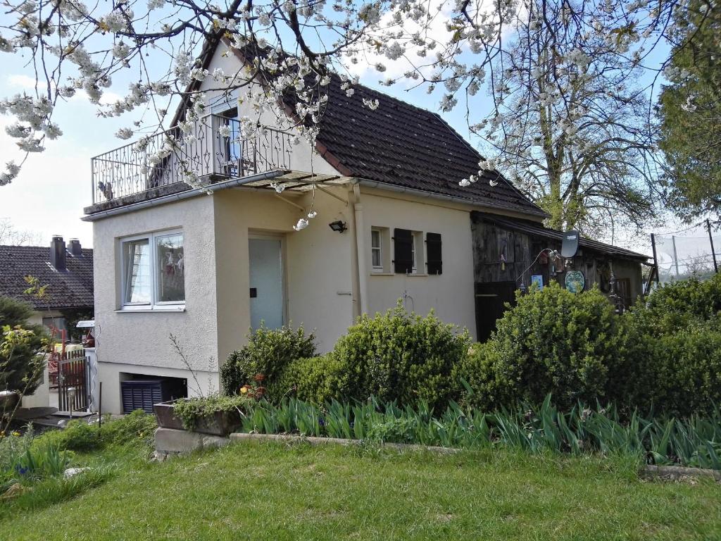 Casa blanca con balcón en la parte superior. en Ferienhaus Aßmus en Weißenburg in Bayern