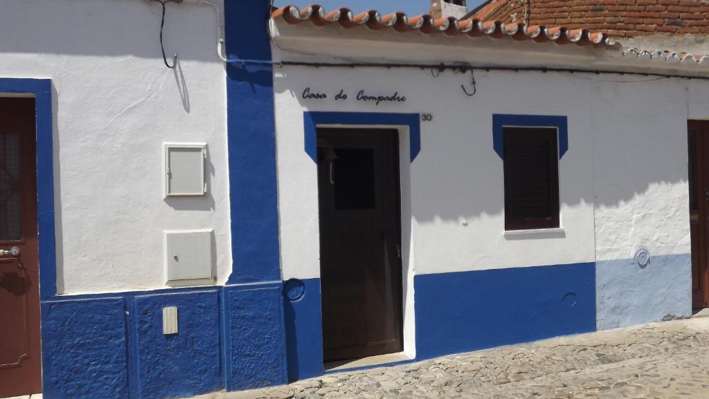 un edificio azul y blanco con puerta en Casa do Compadre - Casas de Taipa, en São Pedro do Corval