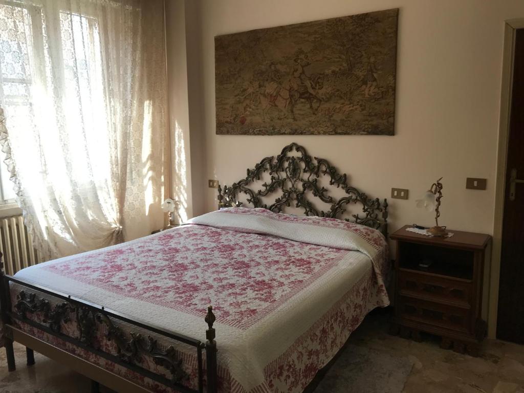 a bedroom with a bed with a red and white bedspread at La Lanterna di Lida e Beppe in Pisa
