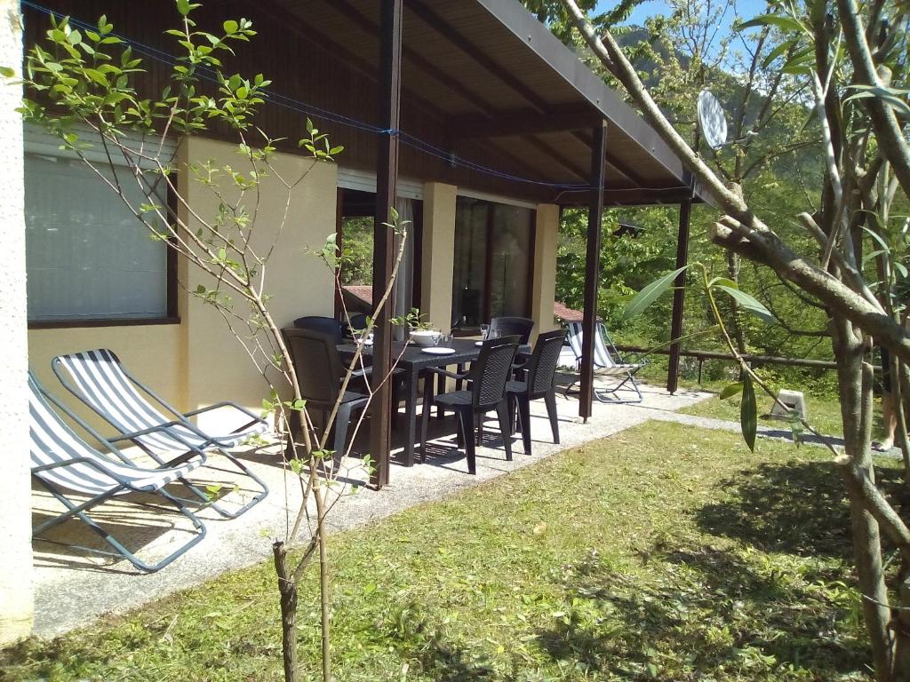 een patio met een tafel en stoelen op een huis bij Sunclass Tignale bungalow S37 in Tignale