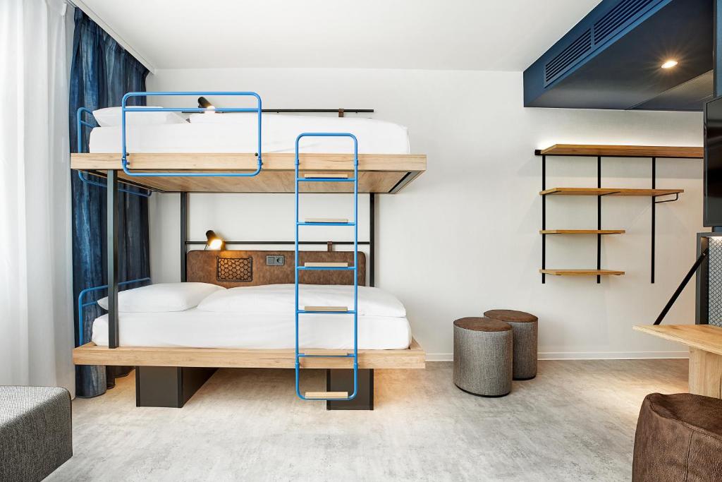 a bunk bed room with two beds and shelves at H2 Hotel München Olympiapark in Munich