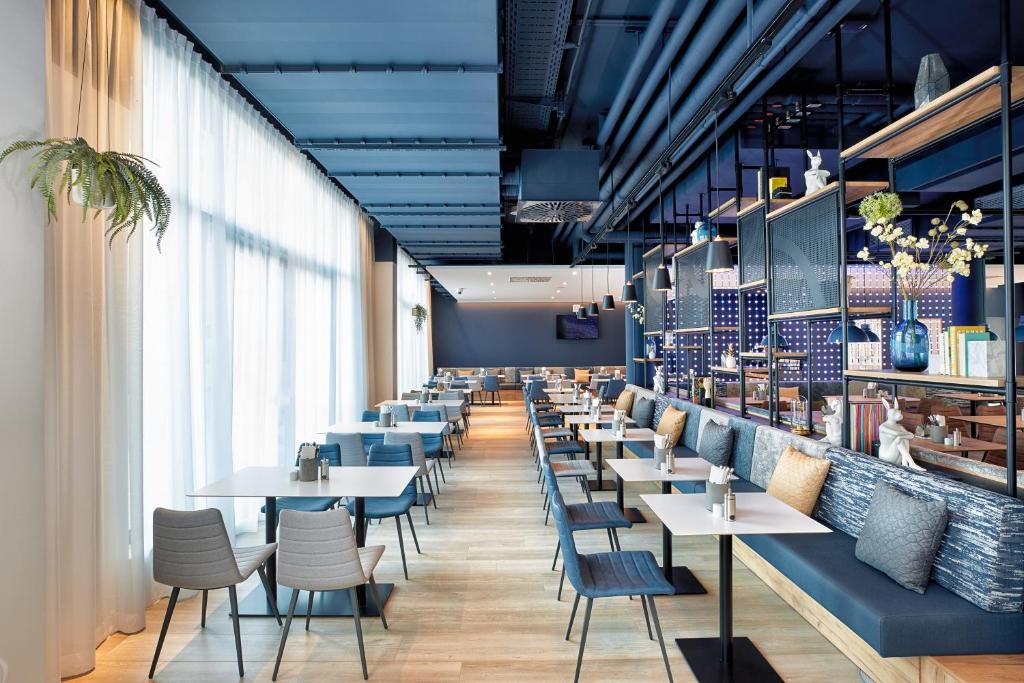 a row of tables and chairs in a restaurant at H2 Hotel München Olympiapark in Munich