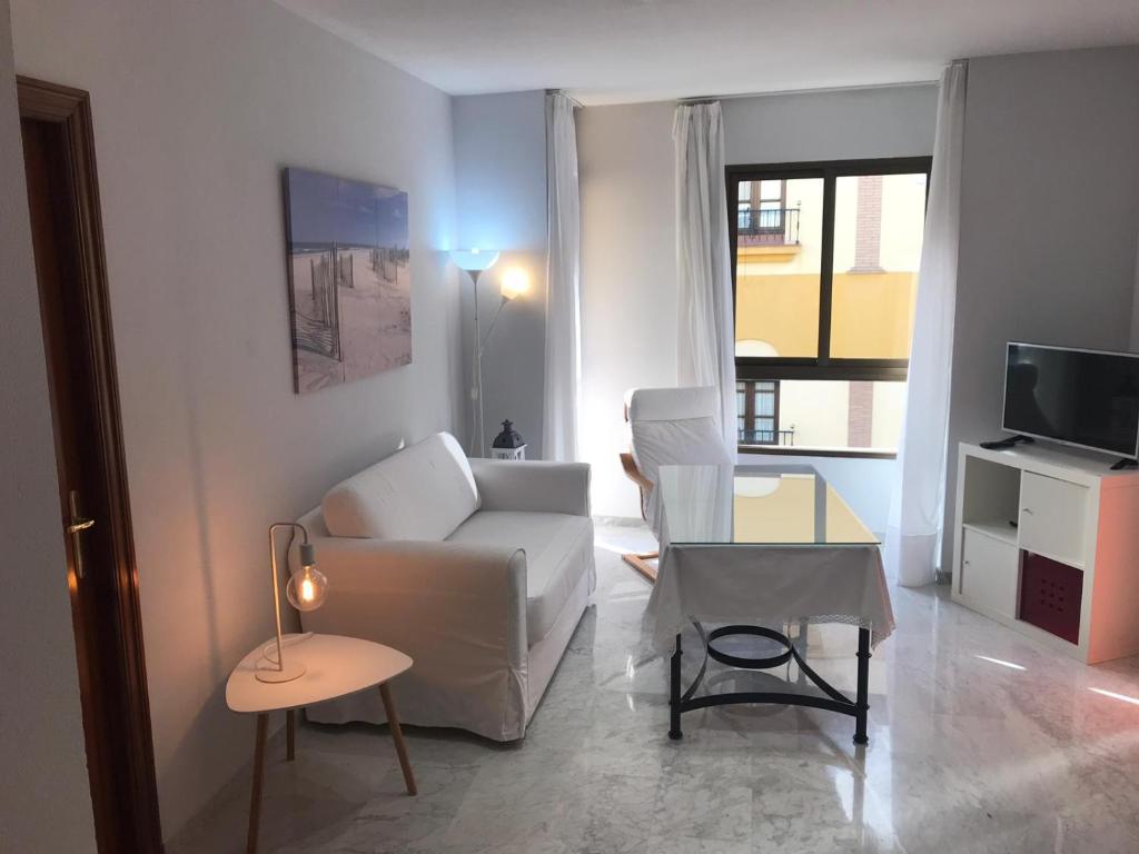 a living room with a white couch and a table at Center Flat Reyes Catolicos in Córdoba