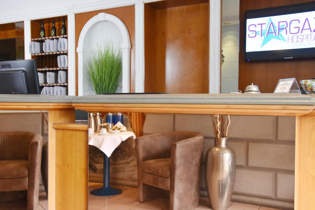 a bar in a restaurant with chairs and a tv at Palazzo Hotel - direkt im Zentrum in Mönchengladbach