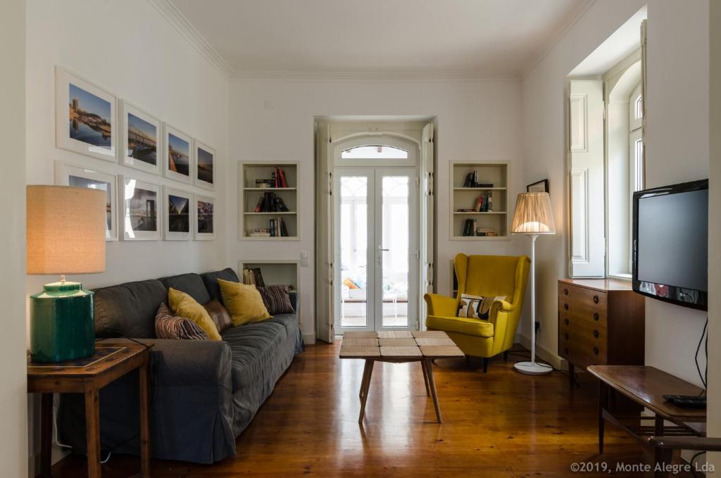 - un salon avec un canapé et un fauteuil jaune dans l'établissement Casa do Tamariz, XIX century Beach House, à Estoril