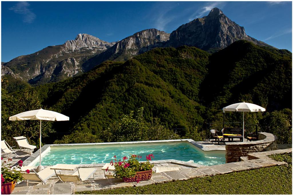 a swimming pool with mountains in the background at Borgo delle Panie in Careggine