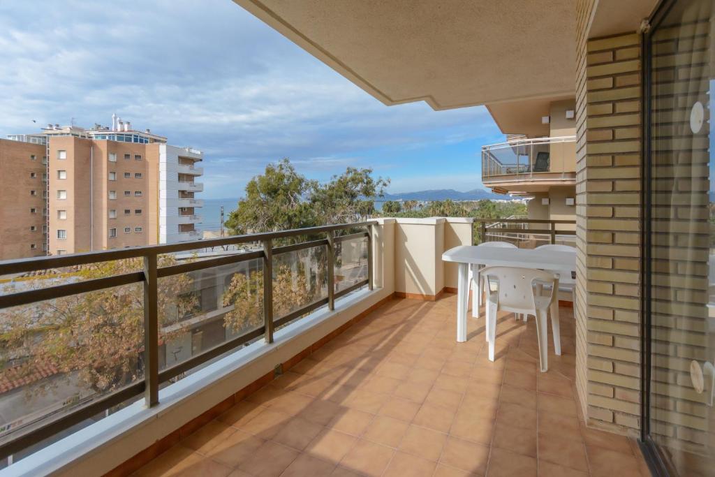 a balcony with a white table and chairs on it at Zeus Sant Jordi in Salou