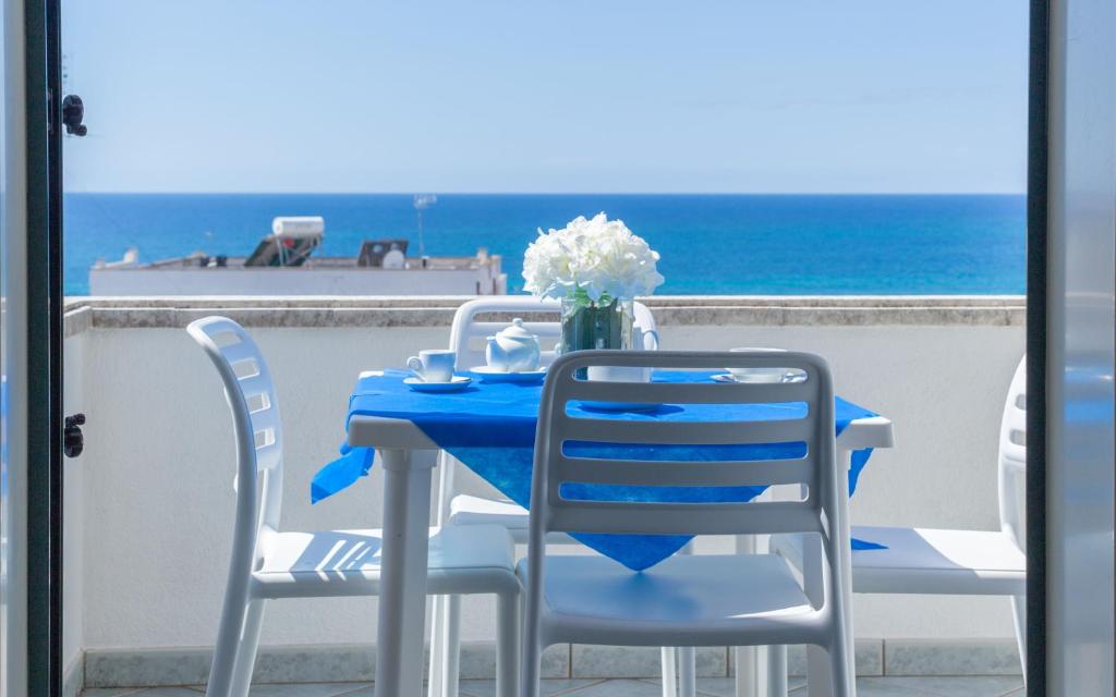 niebieski stół i krzesła na balkonie z widokiem na ocean w obiekcie Spiaggia Bianca Apartments w mieście Torre Vado