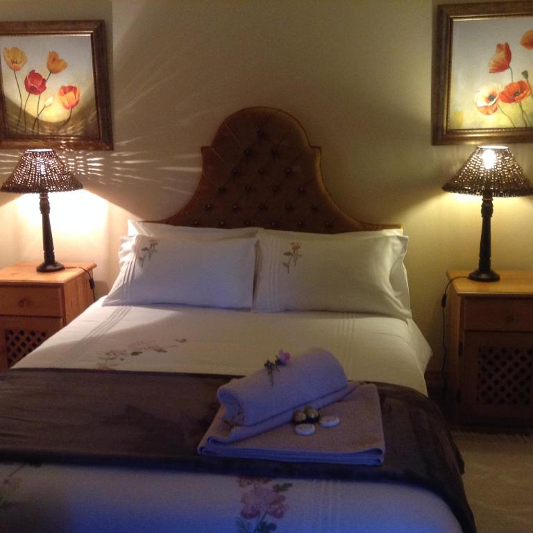 a bed with two lamps and two towels on it at LAVENDERS COTTAGE in Prince Albert