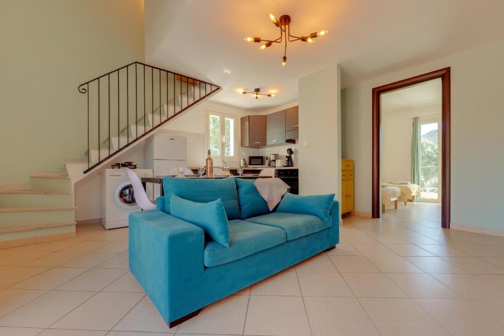 - un canapé bleu dans le salon avec un escalier dans l'établissement Terrazza Soli Mare, à Belgodère