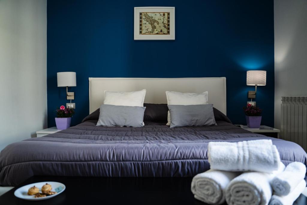a bedroom with a large bed with blue walls at Le Due Sicilie B&B in Lascari