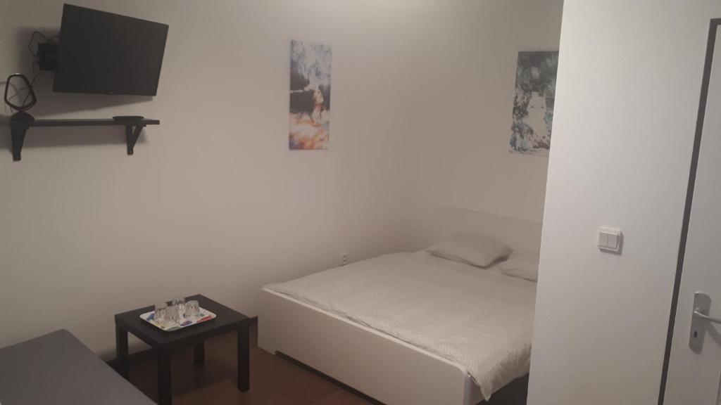 a small bedroom with a bed and a small table at Apartmán - súkromie v meste (1) in Bratislava