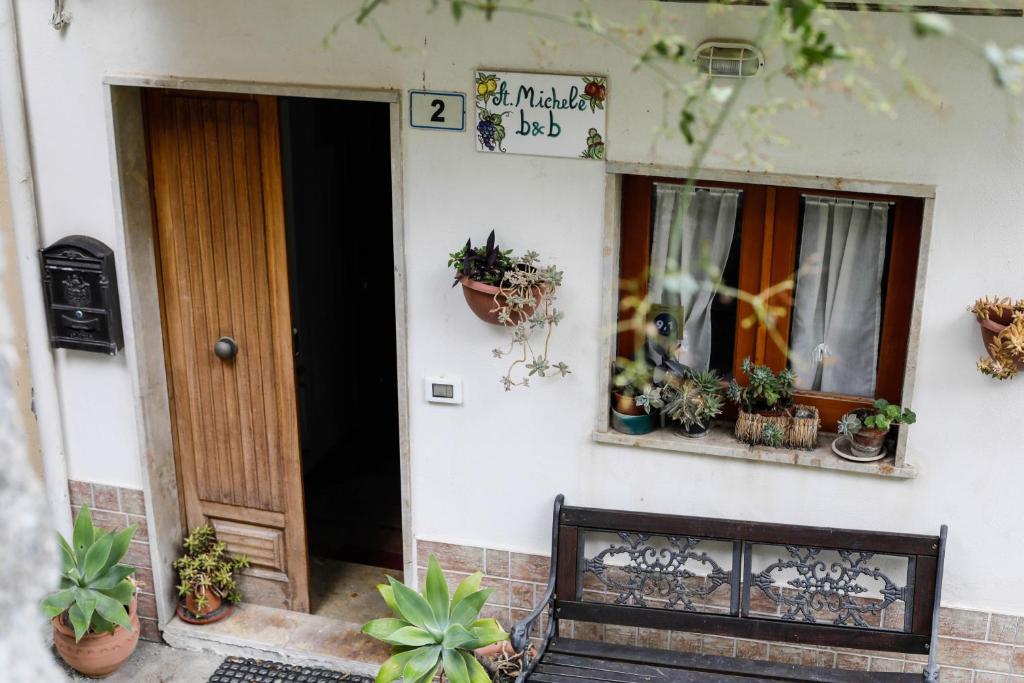 een voordeur van een huis met potplanten bij St. Michele b&b in Patti