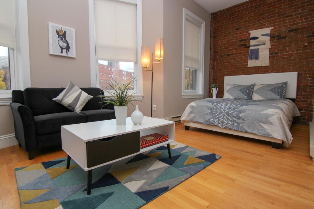 een woonkamer met een bed en een bank bij Charming Studio in Boston Brownstone, C.Ave#5 in Boston