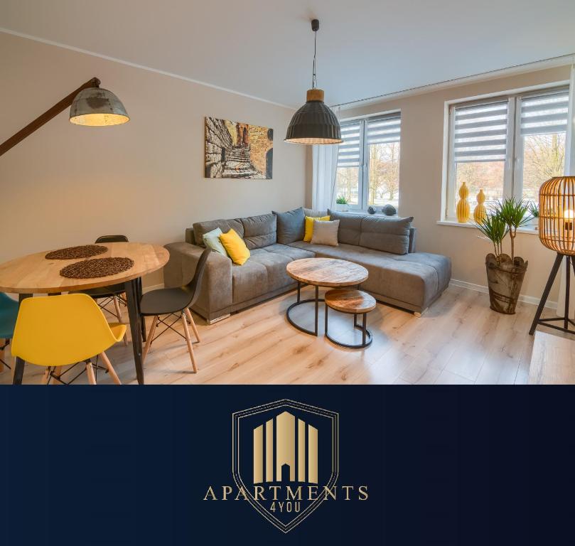 uma sala de estar com um sofá e uma mesa em Apartments 4 You Hlonda em Tychy