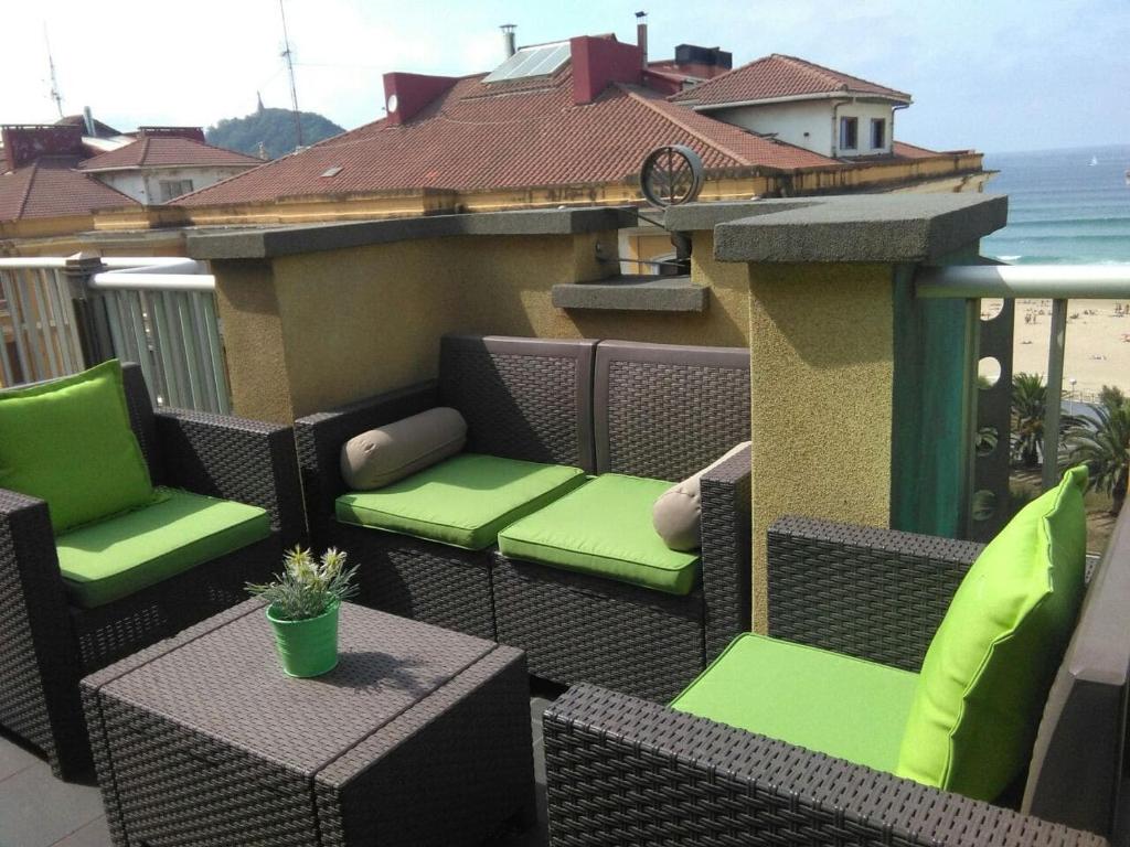 - Balcón con mesa y sillas de mimbre en Attic+views+terrace+parking, en San Sebastián