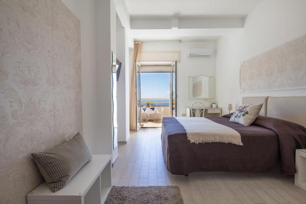 1 dormitorio con cama y vistas al océano en Mini Hotel - Angolo Di Paradiso -, en Pozzuoli