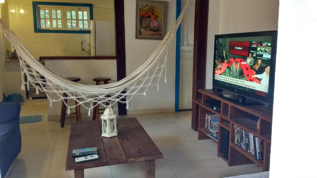 sala de estar con hamaca frente a una TV en Casa no Centro de Búzios, en Búzios