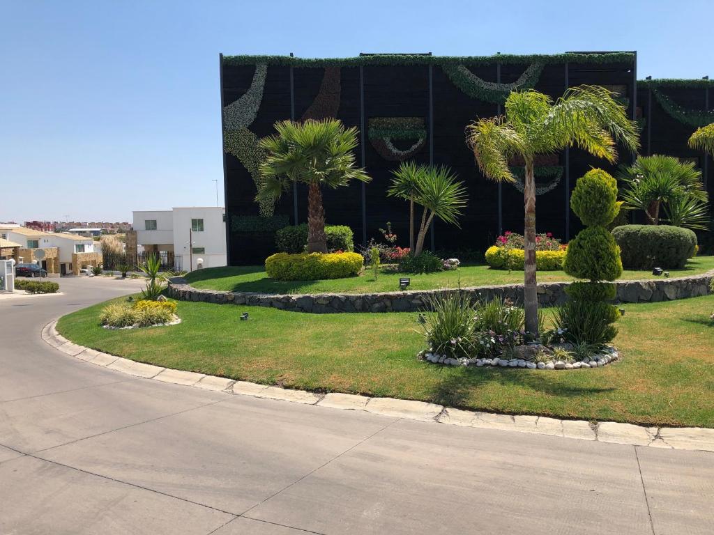 einen Park mit Palmen und Büschen vor einem Gebäude in der Unterkunft Perfect Location & Security @ El Deseo Residencial in Buenavista