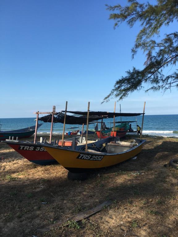 two boats parked on the beach near the ocean at Zara Homestay in Marang