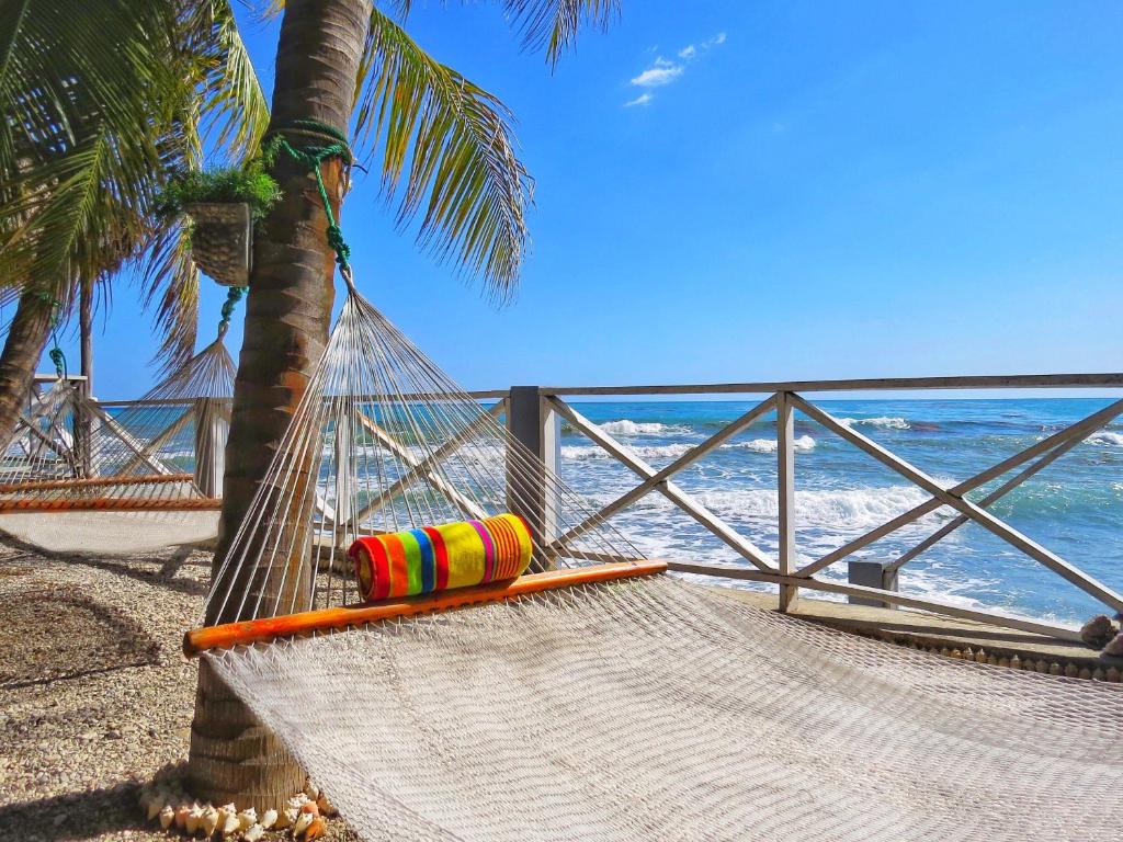 a hammock on a beach next to the ocean at Coterelle Breeze in Cotterelle