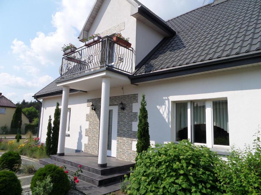 Cette maison blanche dispose d'un balcon. dans l'établissement Dom "Przy Kuźni", à Krotoszyny