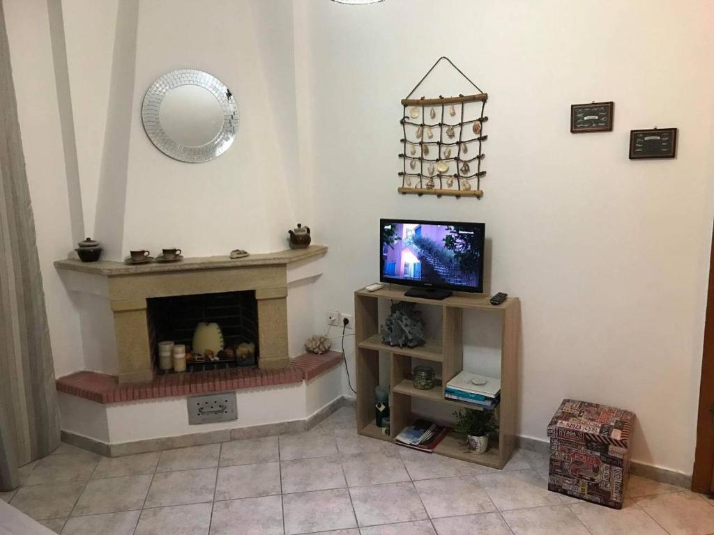 sala de estar con TV y chimenea en Harmony Apartment, en Kallithea Halkidikis