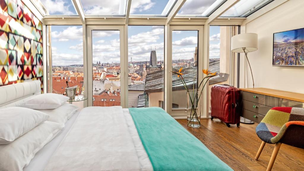 a bedroom with a bed and a large window at Malostranská Residence in Prague